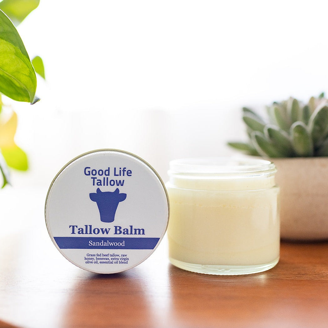 a showcase image of tallow balm on a desk with fresh plants for decor